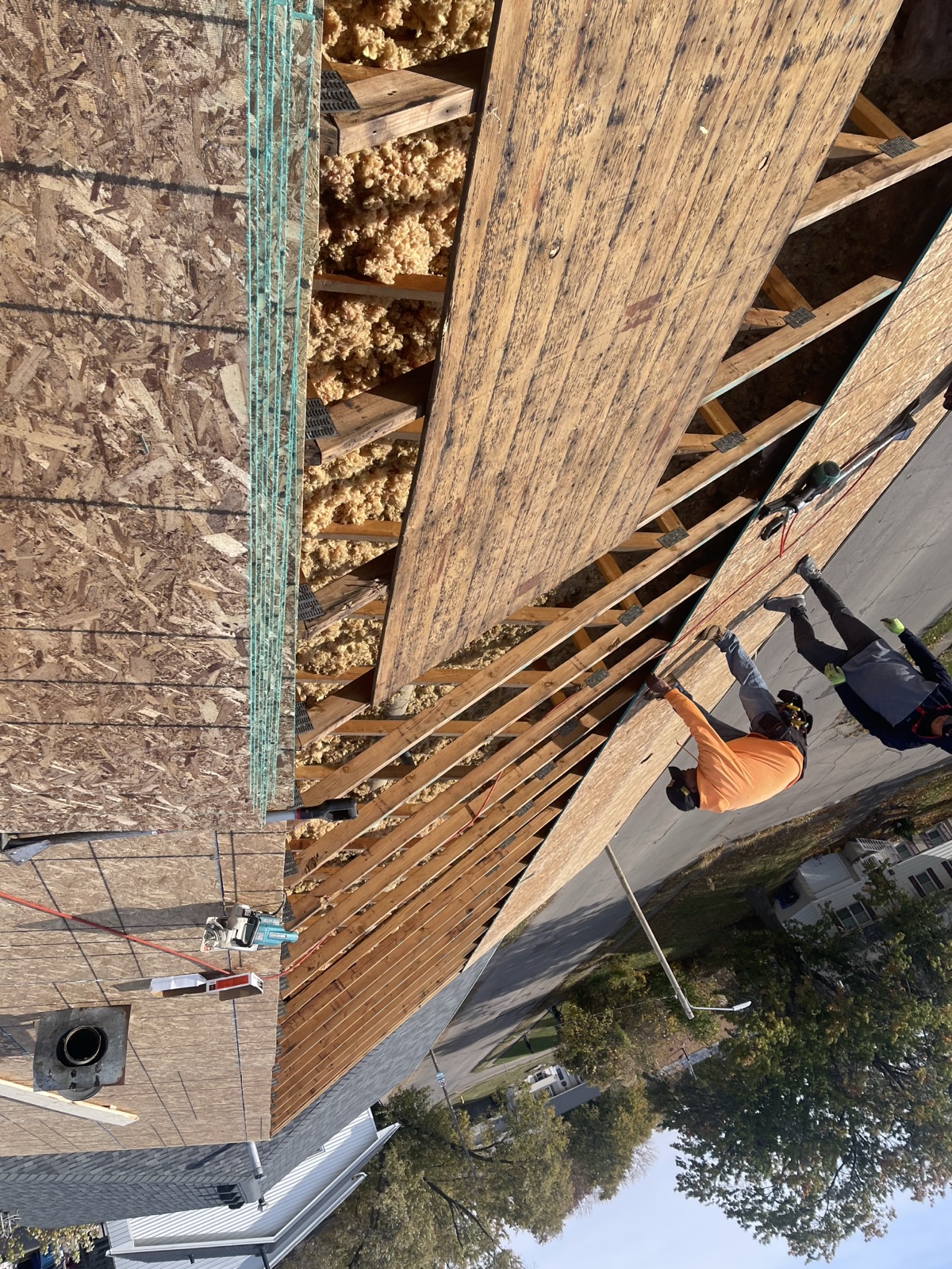 Black Ridge Contracting crew inspecting exposed roof deck and rafters during storm damage tear-off in Des Moines Iowa